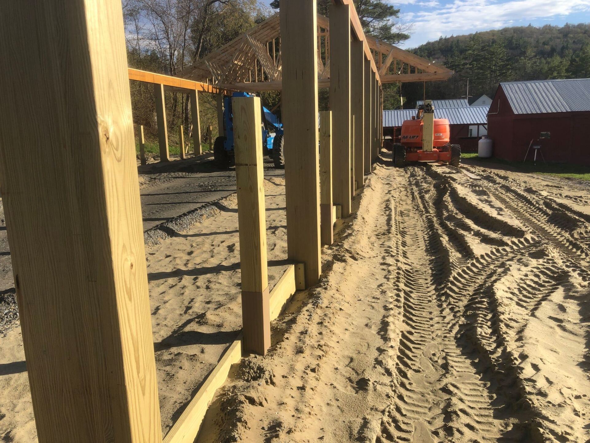 A wooden fence is being built in a dirt field