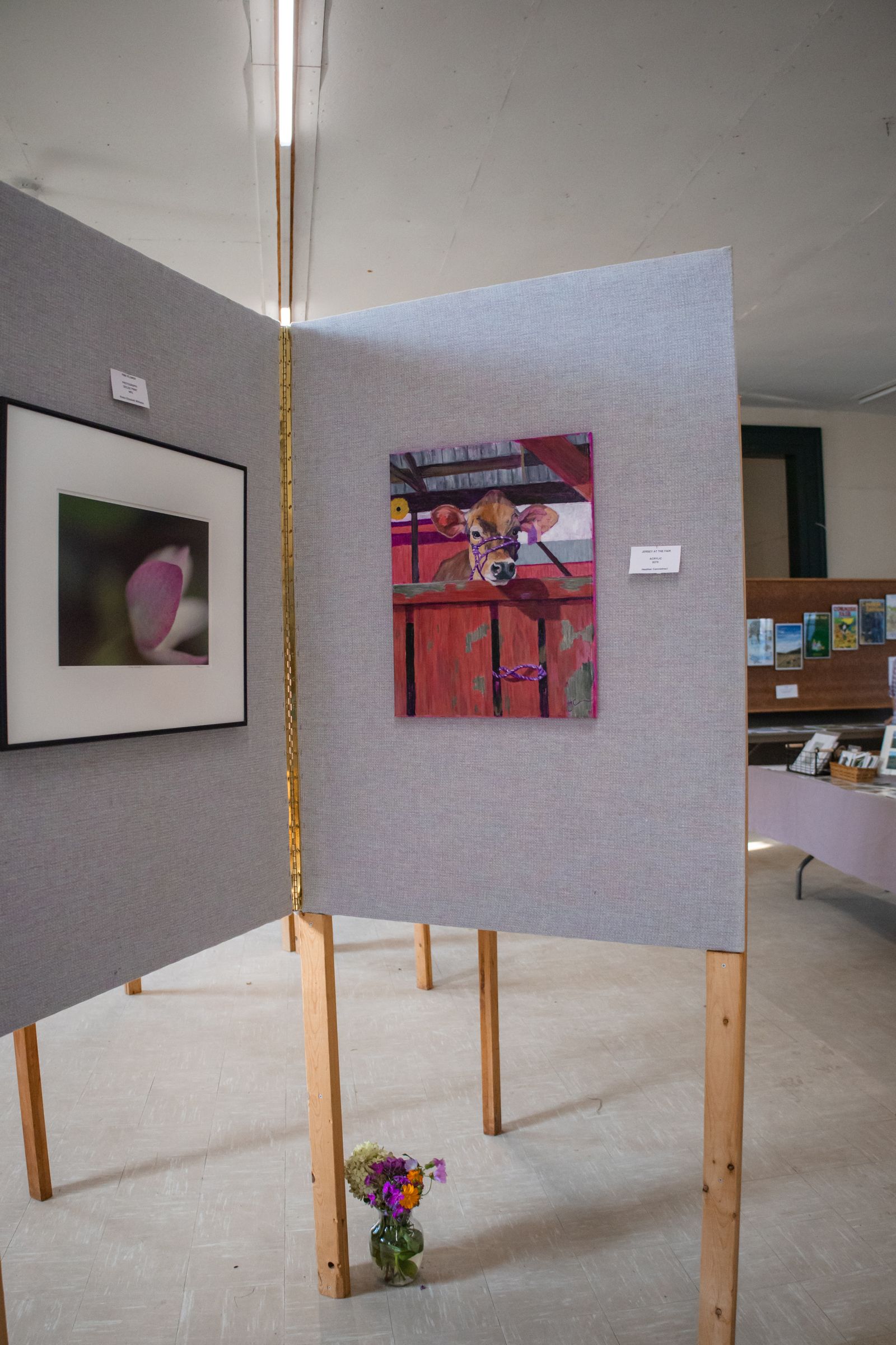 Art display on gray panels with framed paintings in a gallery setting