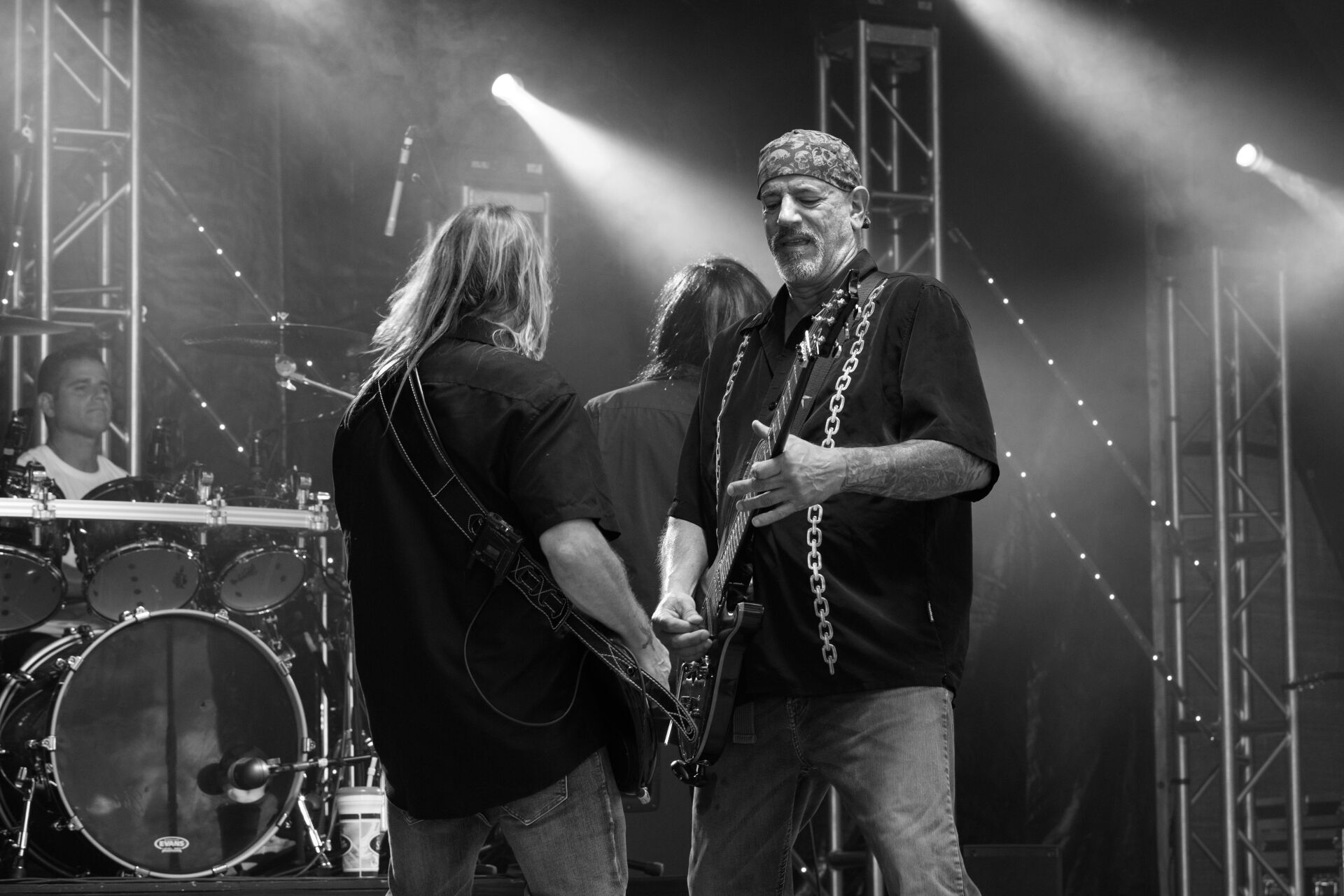 A black and white photo of a man playing a guitar on stage