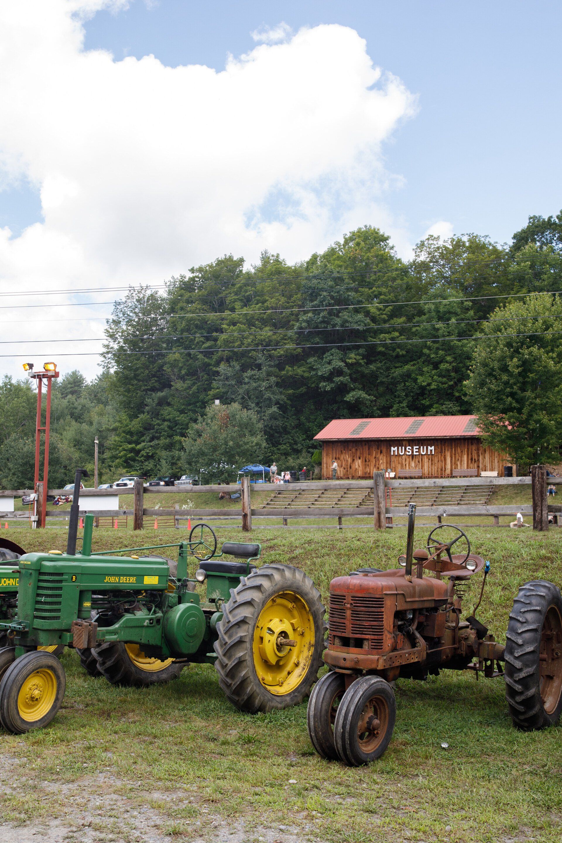Three old john deere tractors are parked in a grassy field