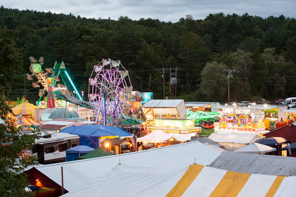 An aerial view of a carnival with a ferris wheel and tents