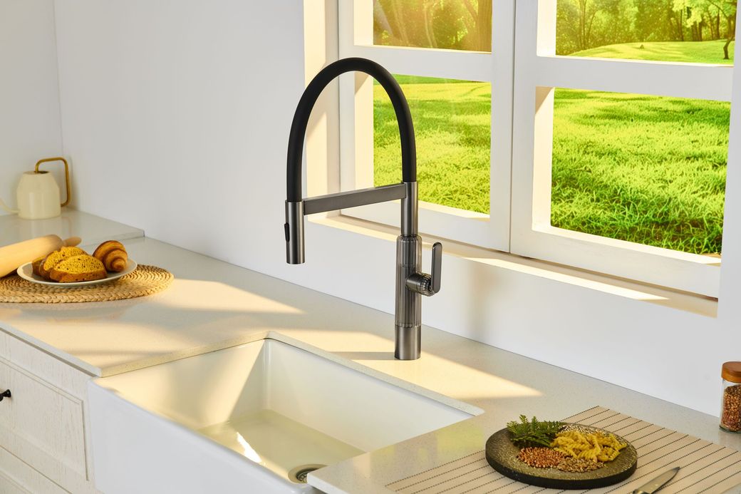 Bright kitchen sink by a window, with fruit on the counter and green lawn outside.