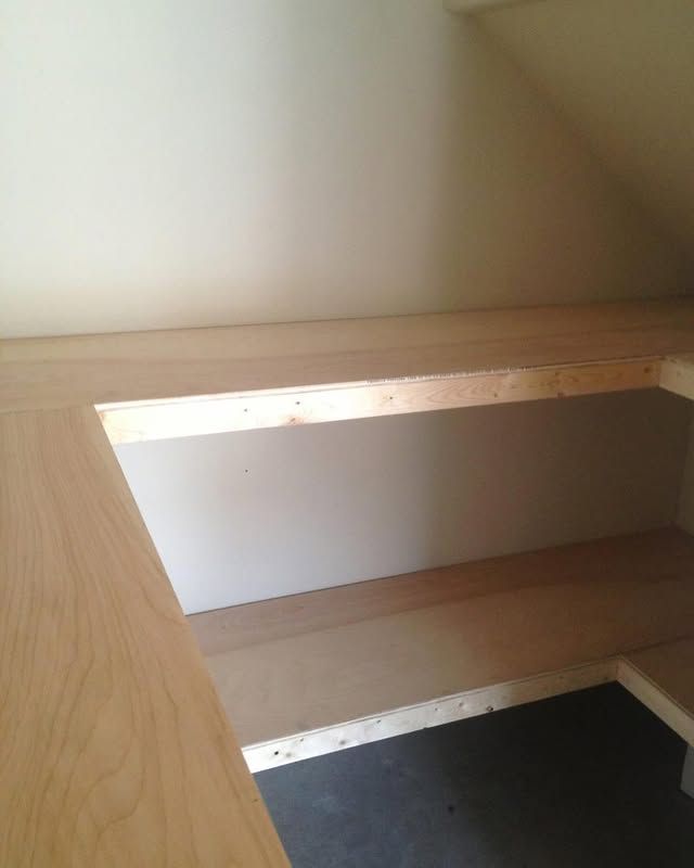 Wooden shelf opening in a light-colored closet or cabinet interior