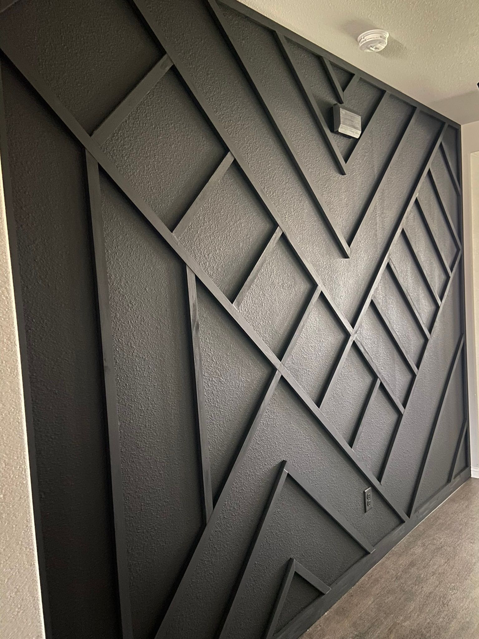 Gray geometric wall art with layered diagonal panels and textured shapes
