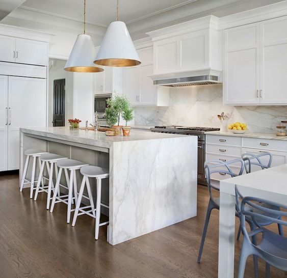 Bright white modern kitchen with marble island, bar stools, and pendant lights