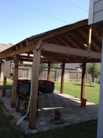 Wooden backyard patio pavilion with exposed rafters, concrete floor, and outdoor grill