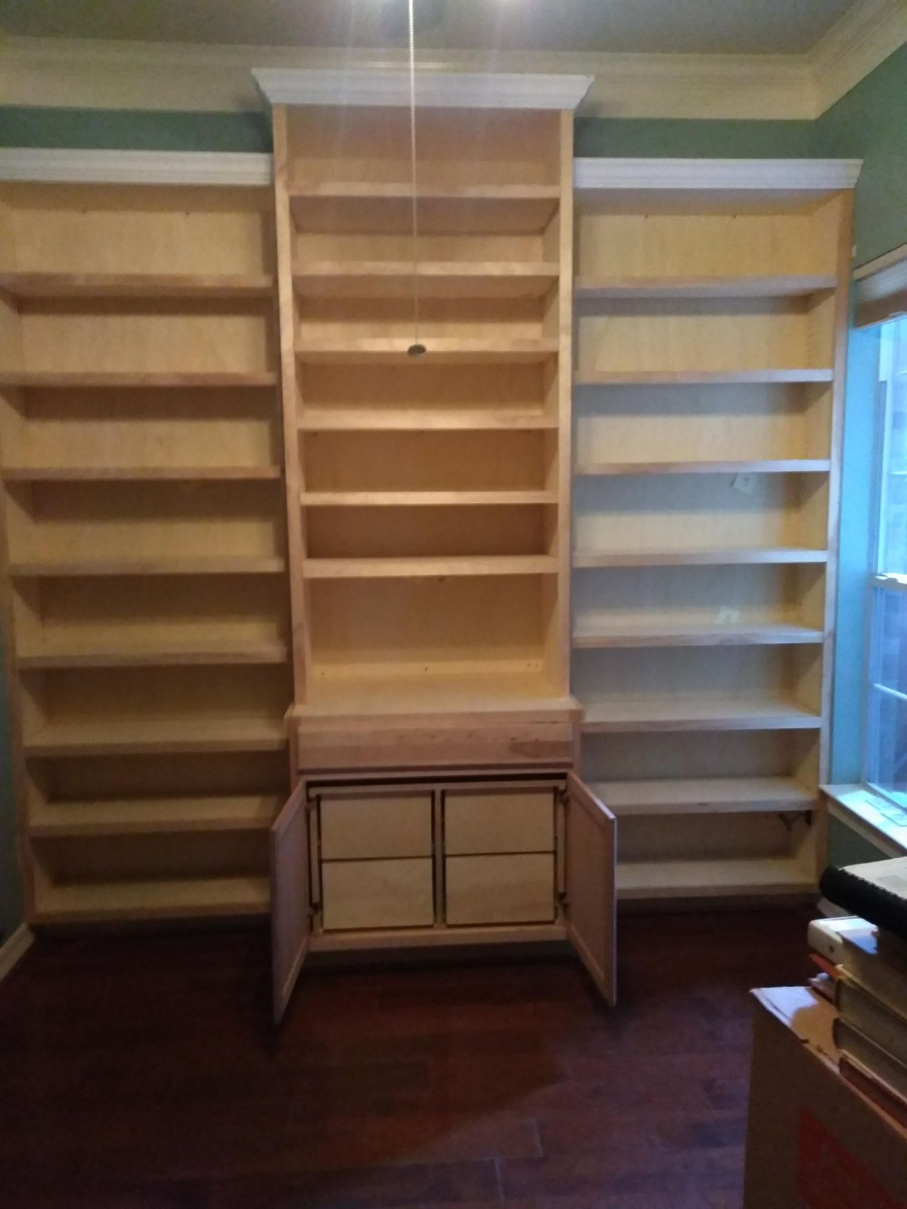Built-in bookshelves with a small cabinet in the center of a room.
