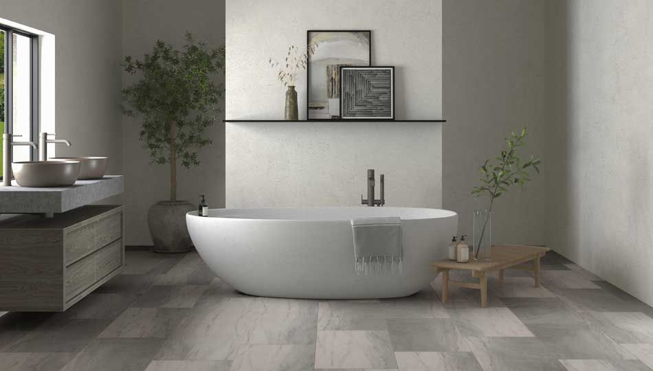 Modern minimalist bathroom with a white freestanding tub, gray tile floor, and shelving with decor.