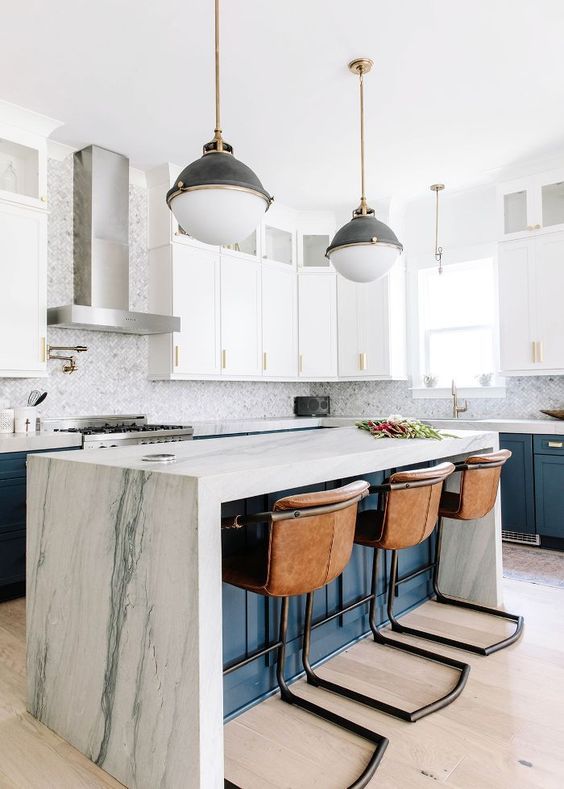 Bright modern kitchen with white cabinets, marble island, and three woven bar stools