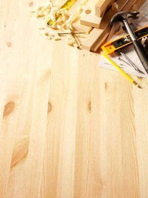 Wooden tabletop with a hammer, pencil, ruler, and wood shavings in the top right corner
