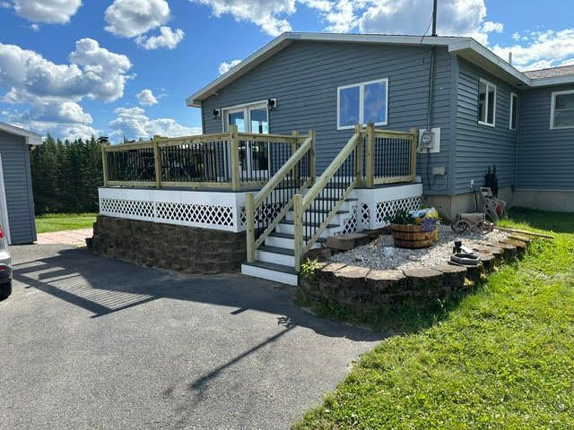 A mobile home with a large deck and stairs
