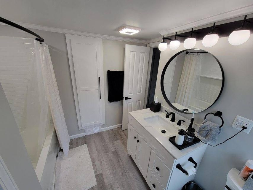A bathroom with a sink and a round mirror
