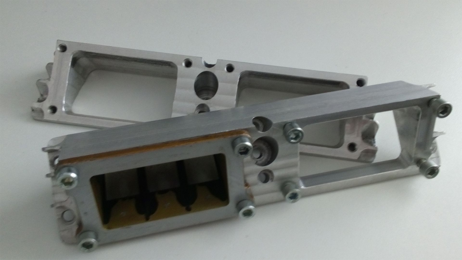Metal mechanical assembly with silver aluminum frame and black internal components on a white background