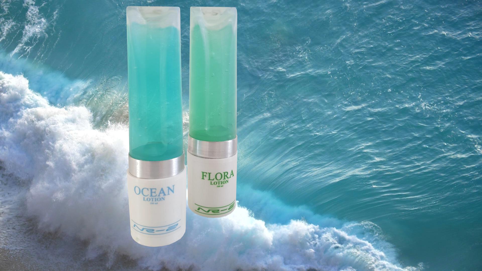 Two turquoise skincare bottles on a wave, with ocean water in the background
