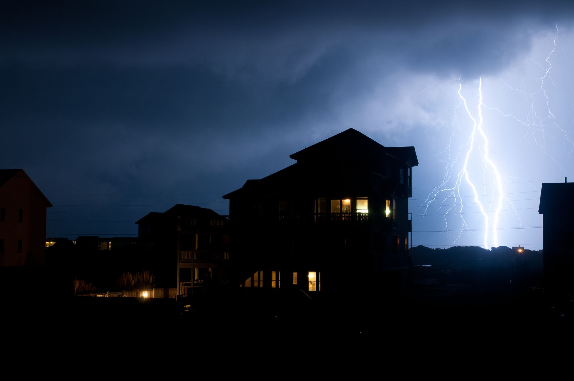 Home with power during a severe thunderstorm, highlighting the benefits of a residential backup generator.