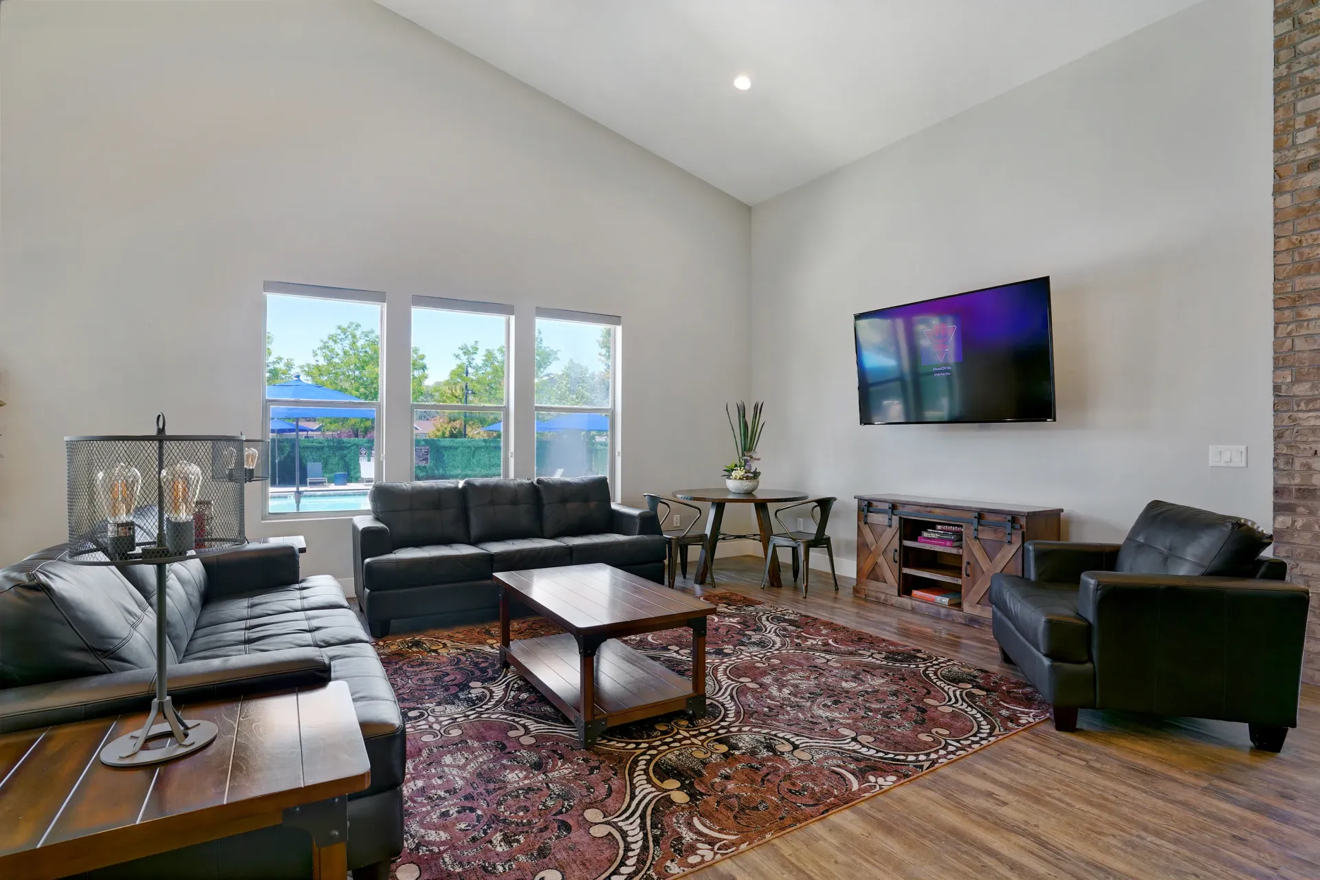 Spacious clubhouse with vaulted ceilings, large windows, plush seating, and a TV at Mountain View Townhomes, offering townhomes in Ogden, UT.