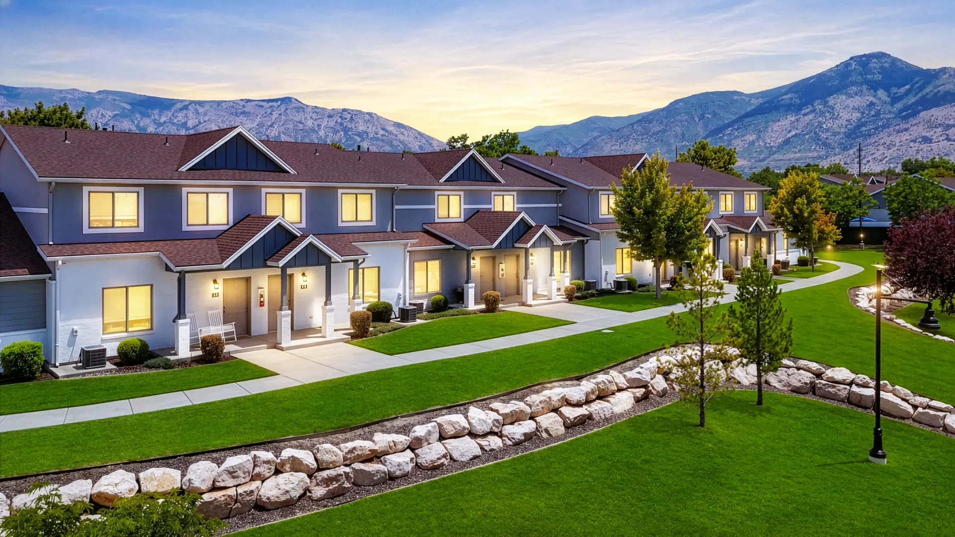Townhomes with manicured lawns and mountain backdrop at sunset at Mountain View Townhomes, offering townhomes in Ogden, UT.