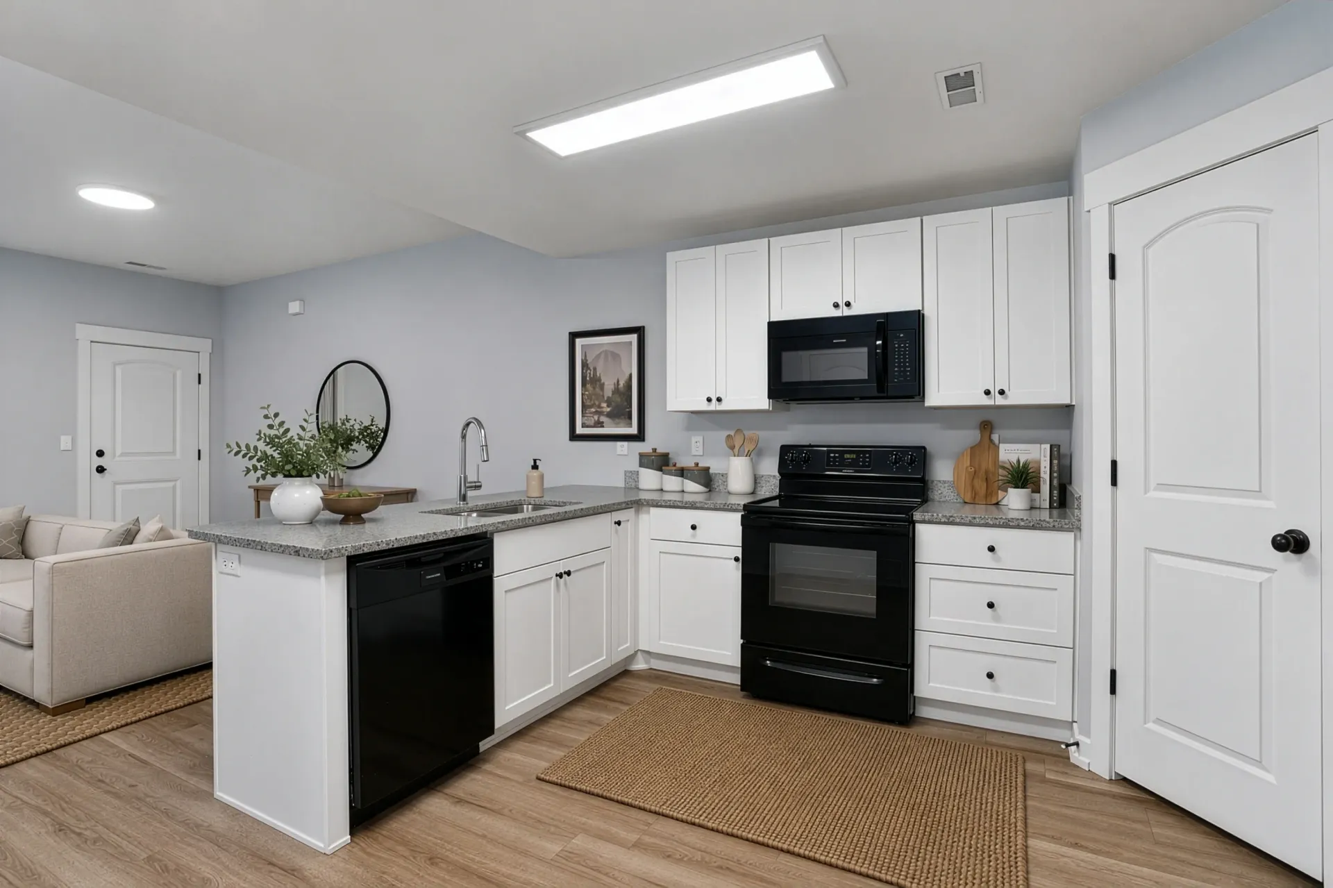 Modern kitchen with white cabinets, black appliances, and granite countertops at Mountain View Townhomes, offering townhomes in Ogden, UT.