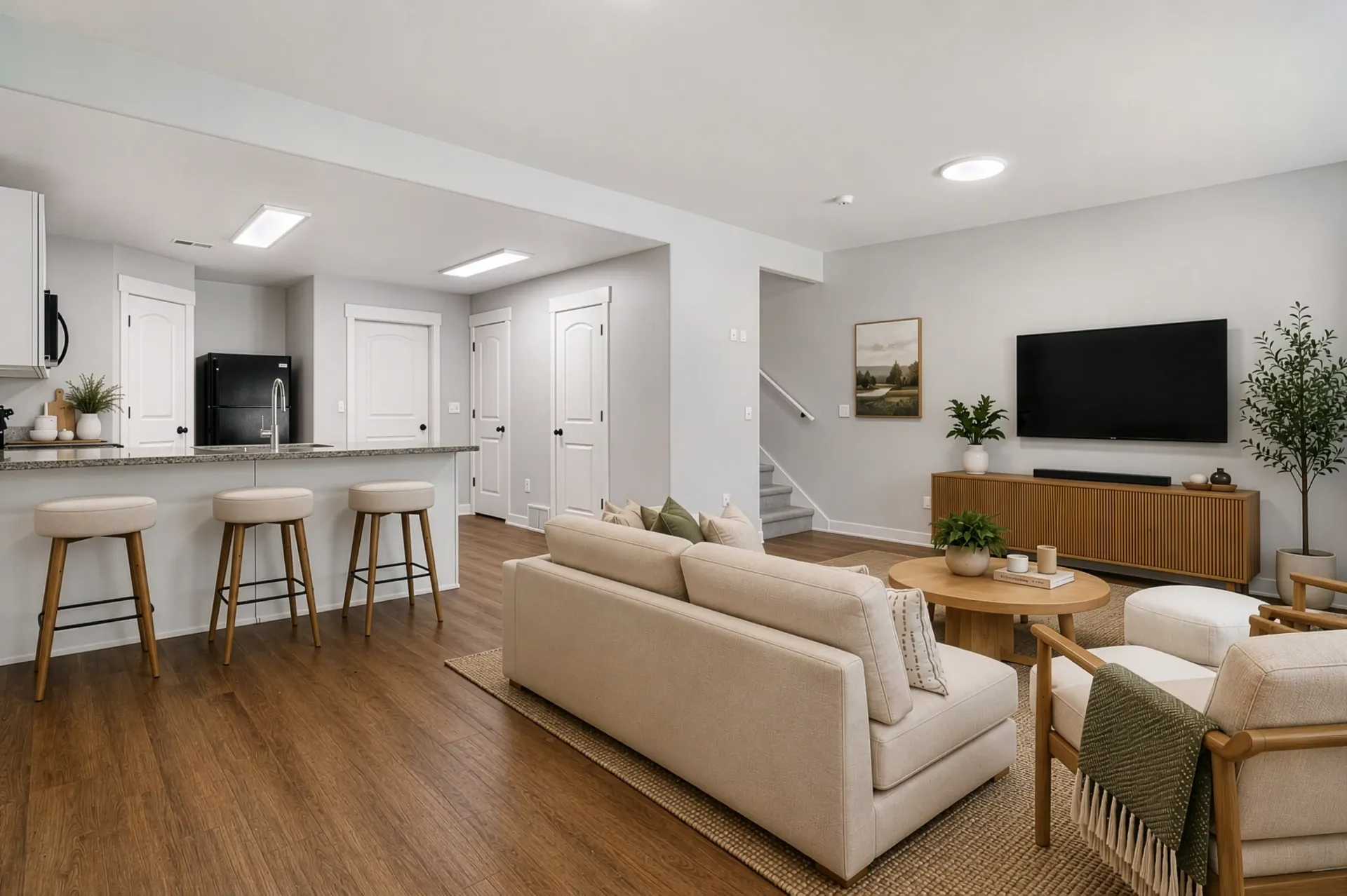 Modern living room with kitchen island and bar stools at Mountain View Townhomes, offering townhomes in Ogden, UT.
