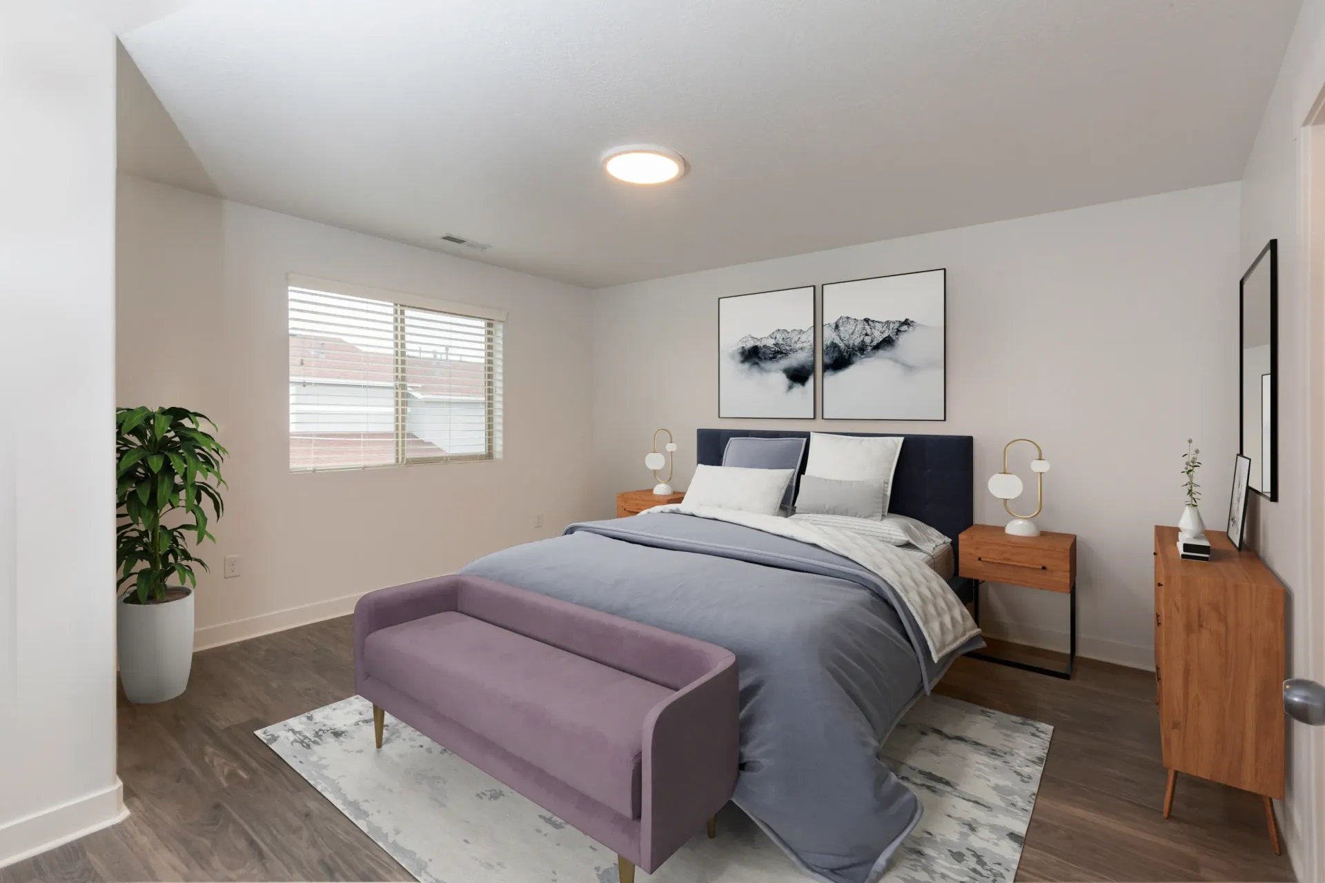 Stylish bedroom with a queen-sized bed, purple bench, and mountain artwork at Mountain View Townhomes, offering townhomes for rent in Ogden, UT.