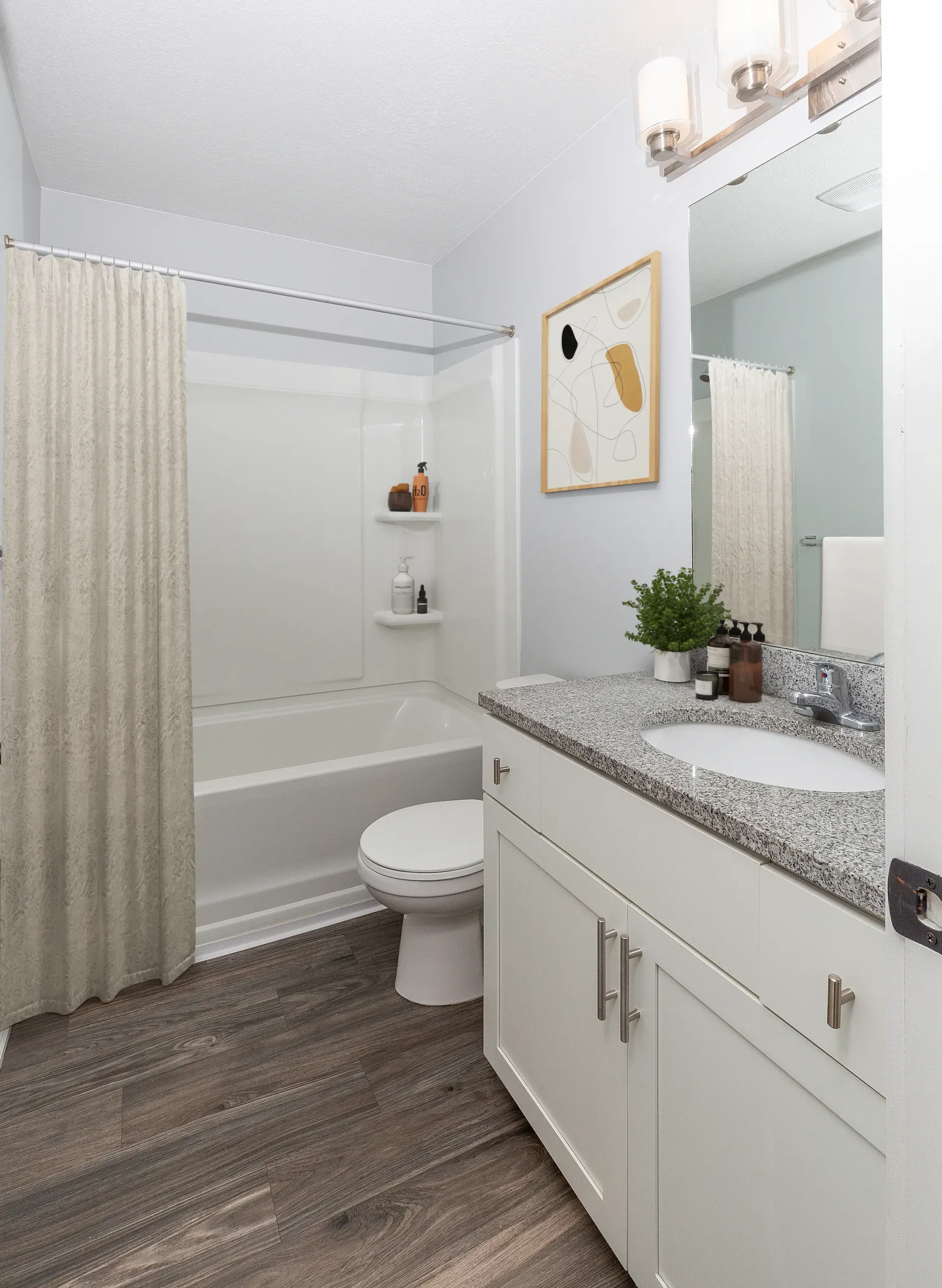 Modern bathroom with a bathtub, toilet, vanity, and sink at Mountain View Townhomes, offering townhomes for rent in Ogden, UT.