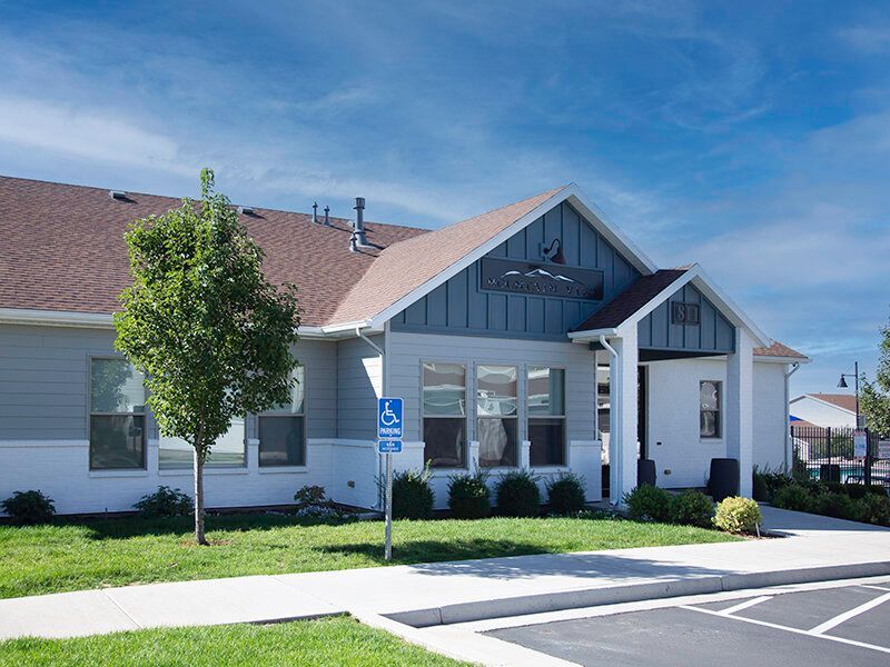 Exterior view of a Mountain View Townhomes with a handicapped parking sign and landscaping.