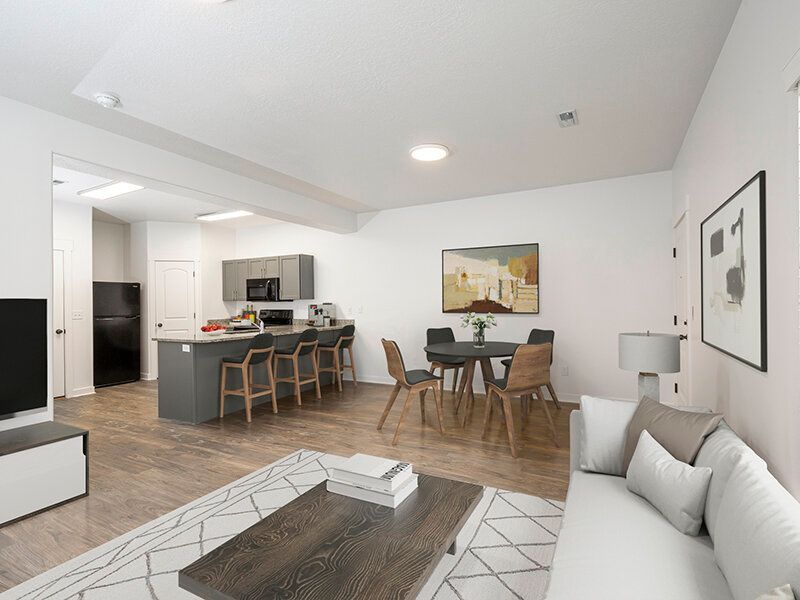 Mountain View Townhomes living area with a sofa, coffee table, dining table, and kitchen island.