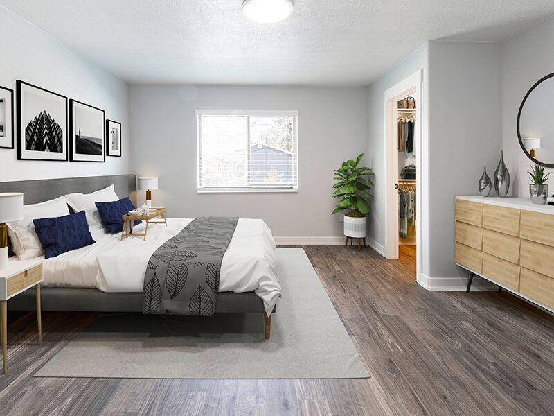 Mountain View Townhomes bedroom with a king-size bed, two nightstands, dresser, plant, and open closet.