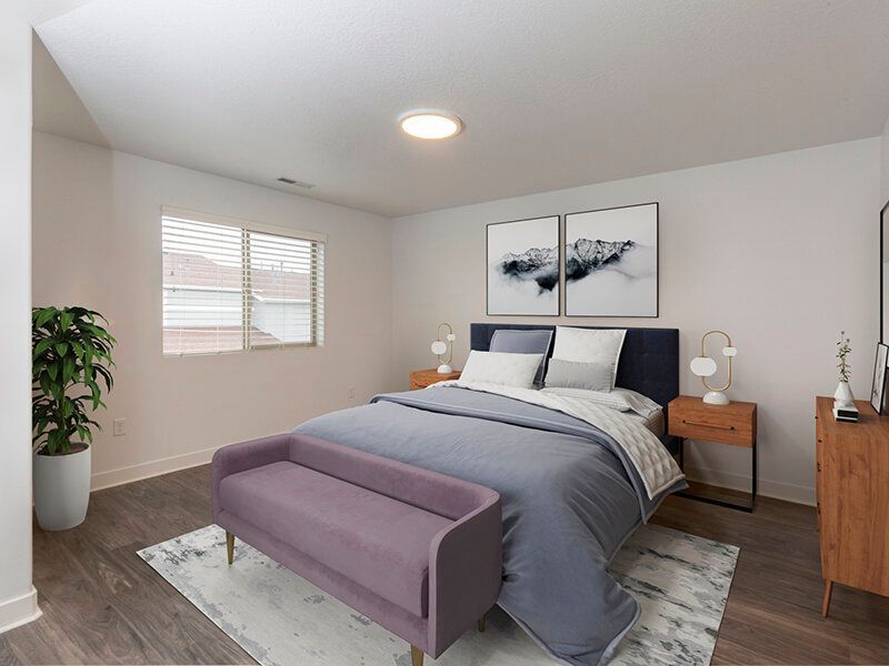 Mountain View Townhomes bedroom with a queen bed, two nightstands, a purple bench at the foot, and a plant.