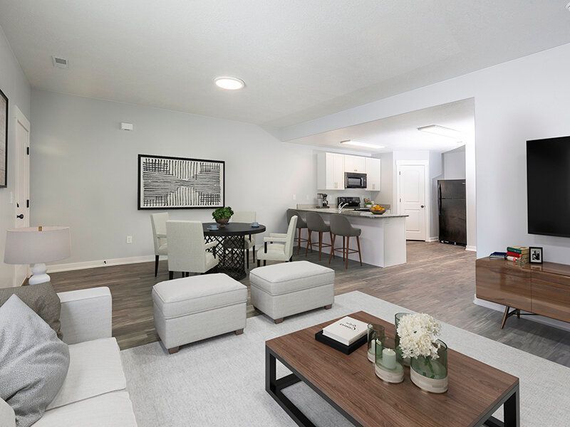 Mountain View Townhomes living area with sofa, coffee table, dining set, and visible kitchen.