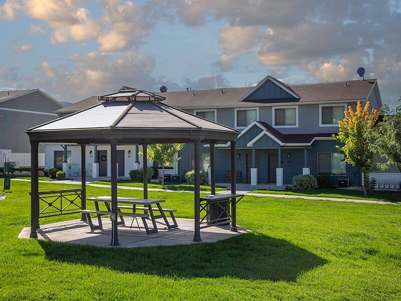 Mountain View Townhomes Gazebo with picnic table in a grassy courtyard of an apartment community.
