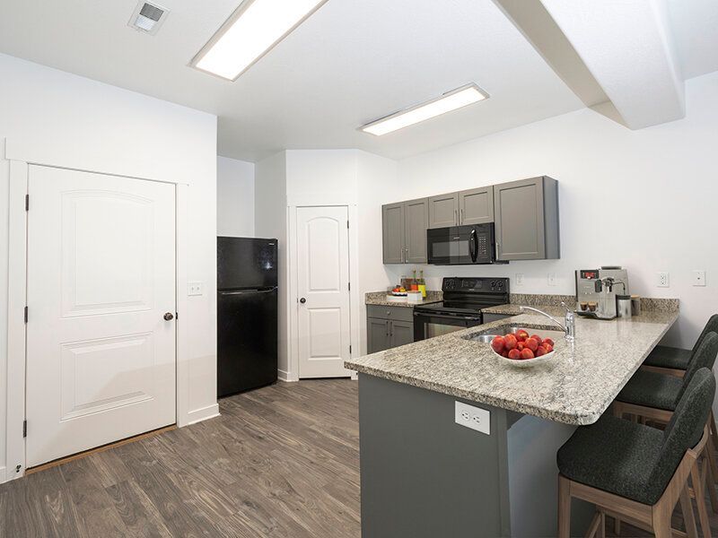 Mountain View Townhomes kitchen with granite island, gray cabinets, and stainless-steel appliances.
