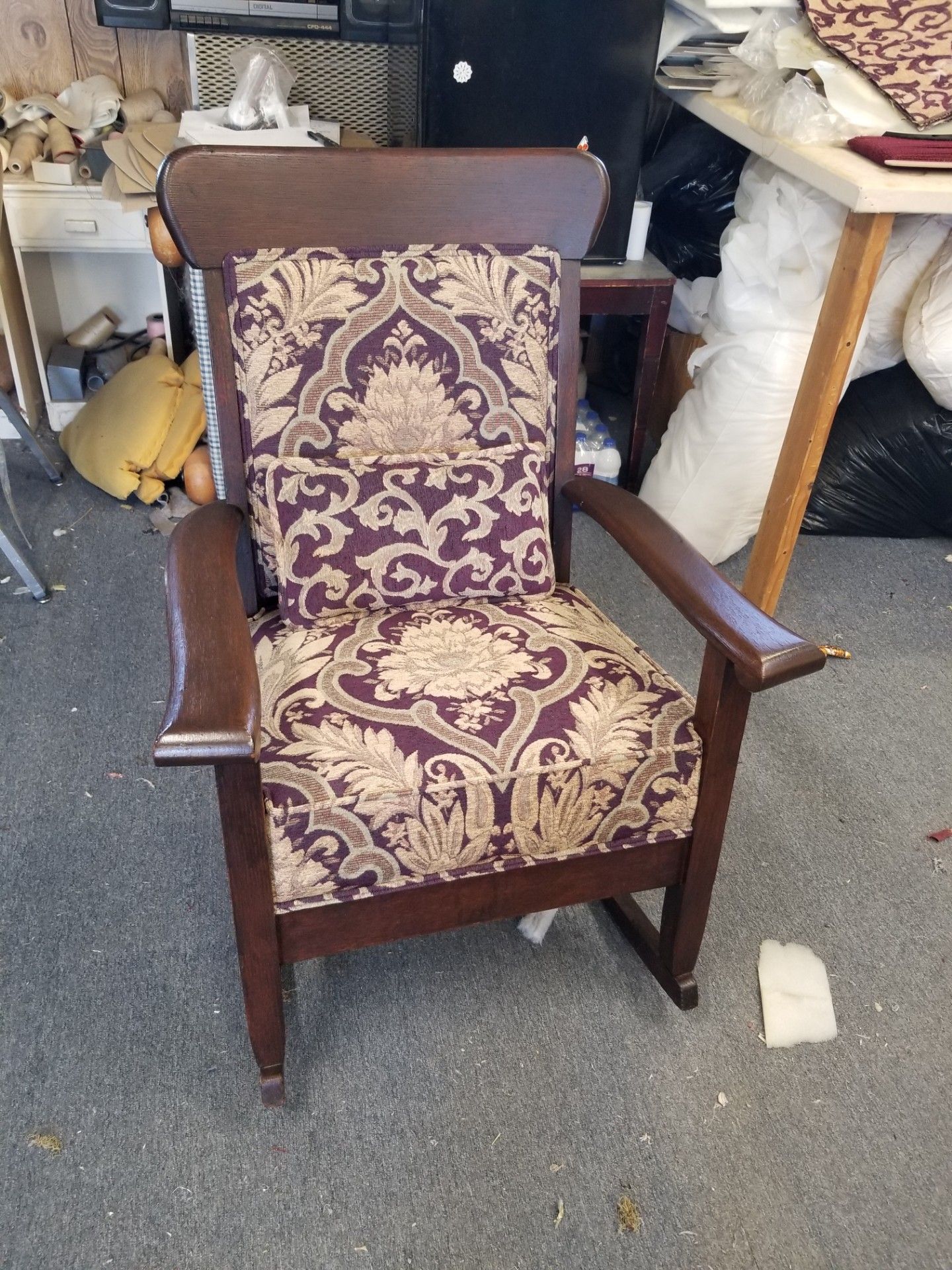 Wooden armchair with purple and gold patterned upholstery.