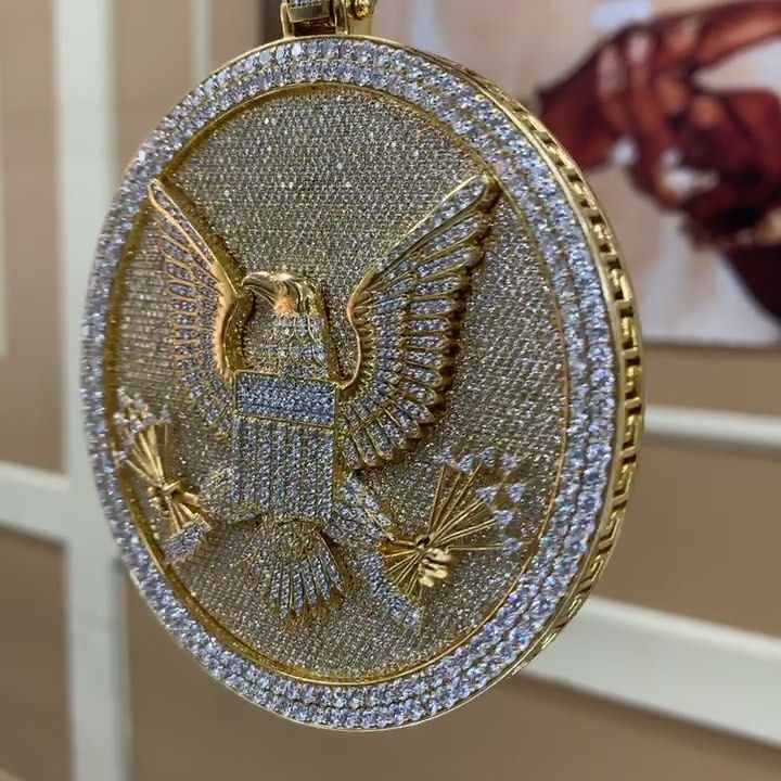 Gold U.S. Department of Justice seal on a wall display, featuring an eagle and stars