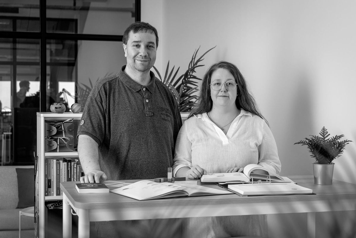 Christina og Holger fra Saysome står ved et bord med bøger og materialer