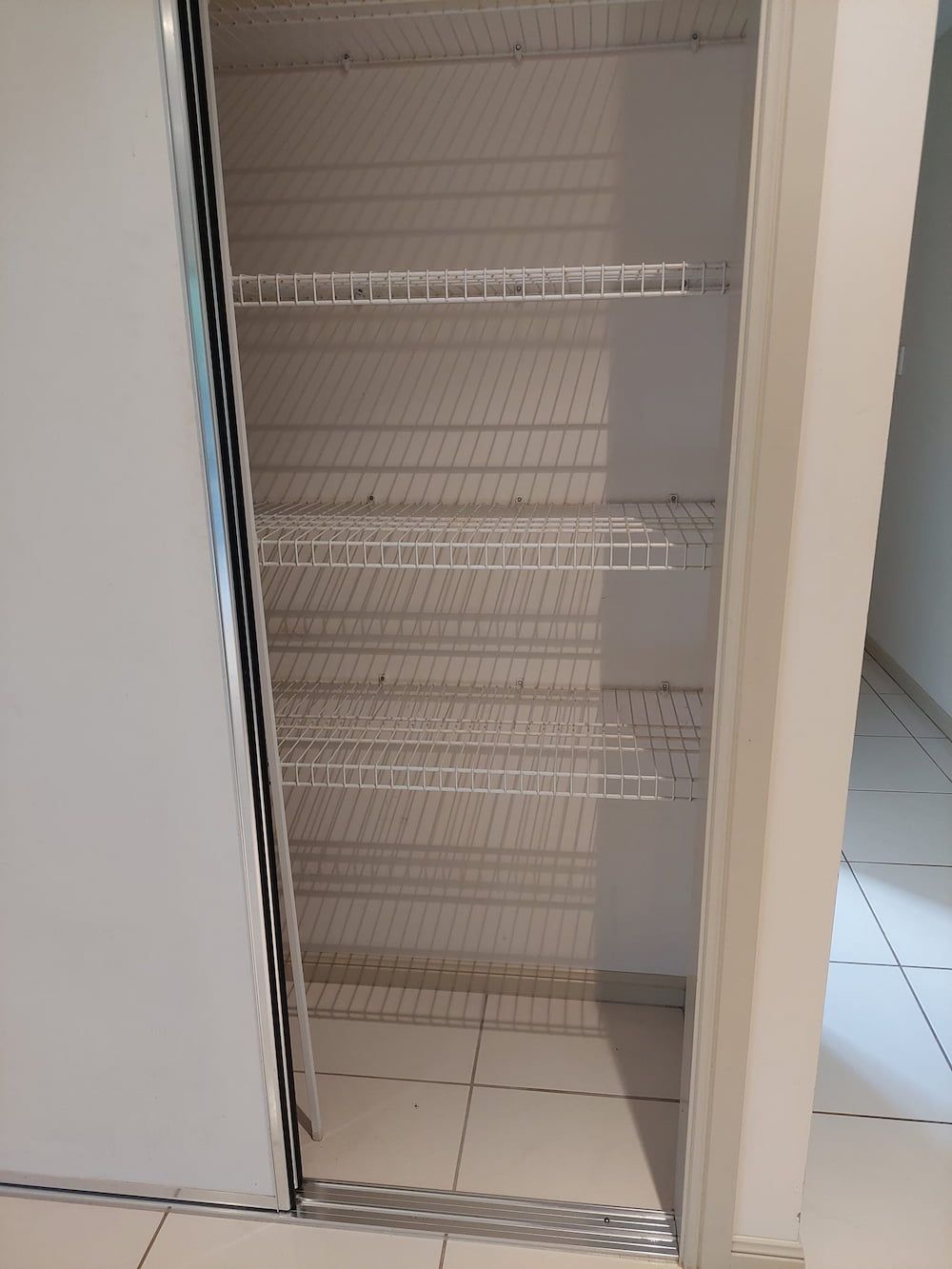Empty Wire Shelving in a White-walled Closet — DAH Cleaning Services In Bungalow, QLD