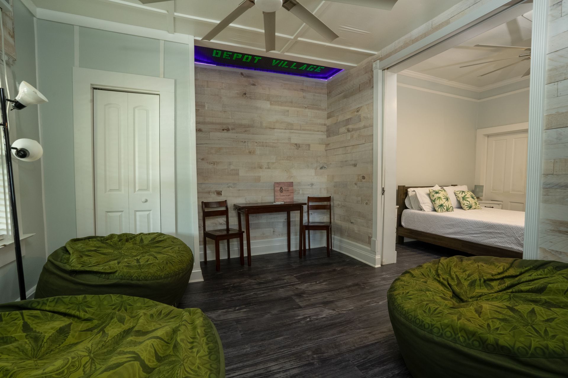 Interior room with bean bag chairs, table, chairs, and bedroom visible.