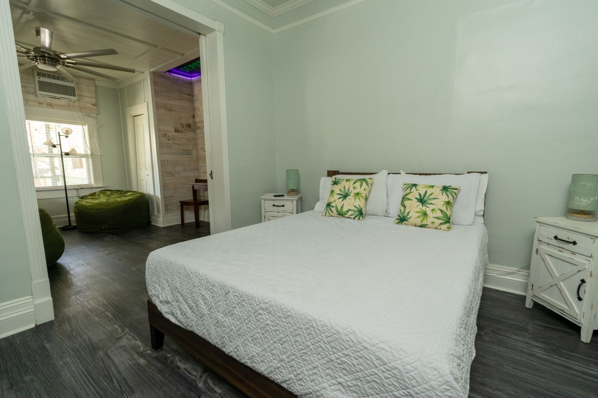 Bedroom with a white bed, green walls, and two white nightstands.