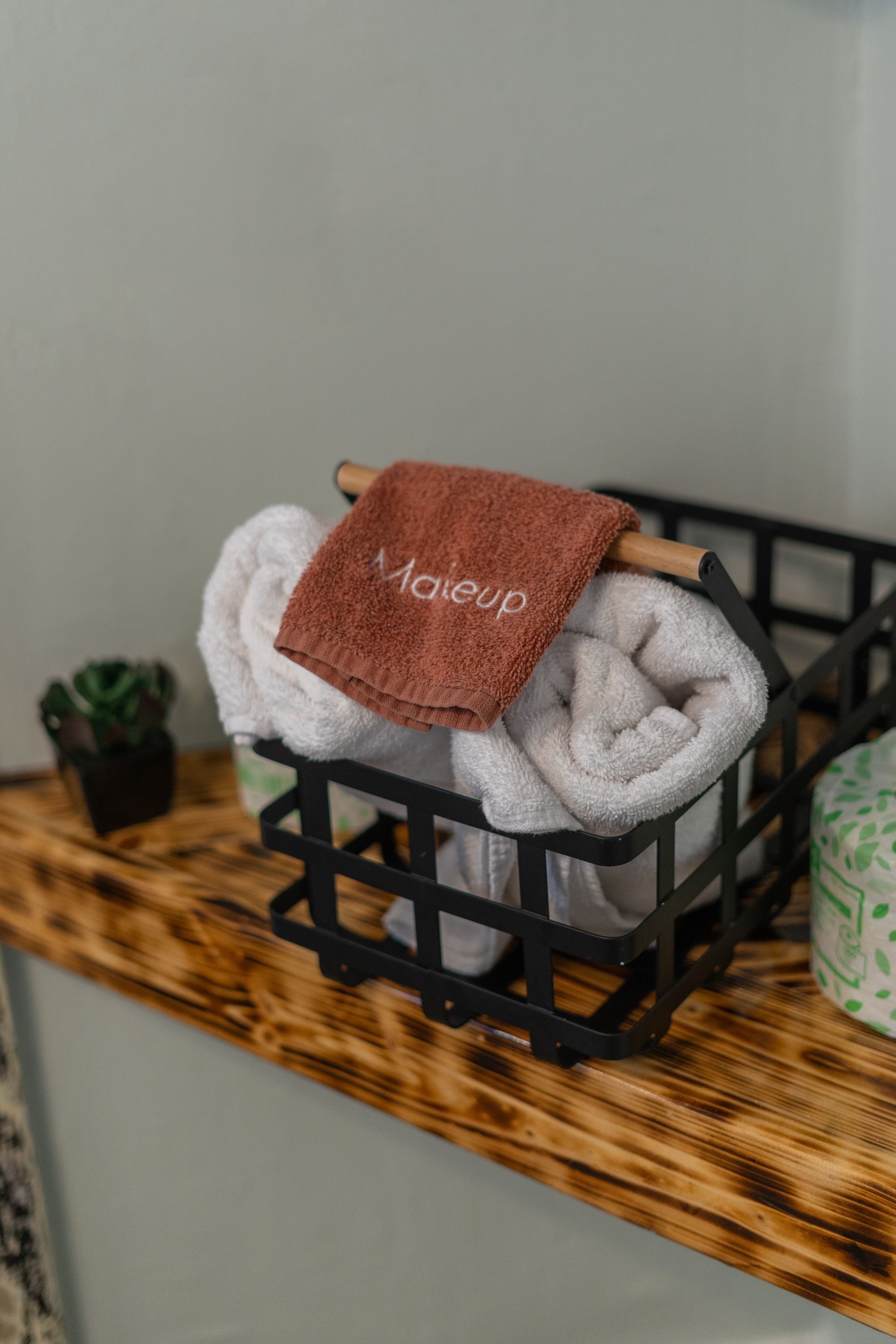 Basket with rolled white towels and a brown 