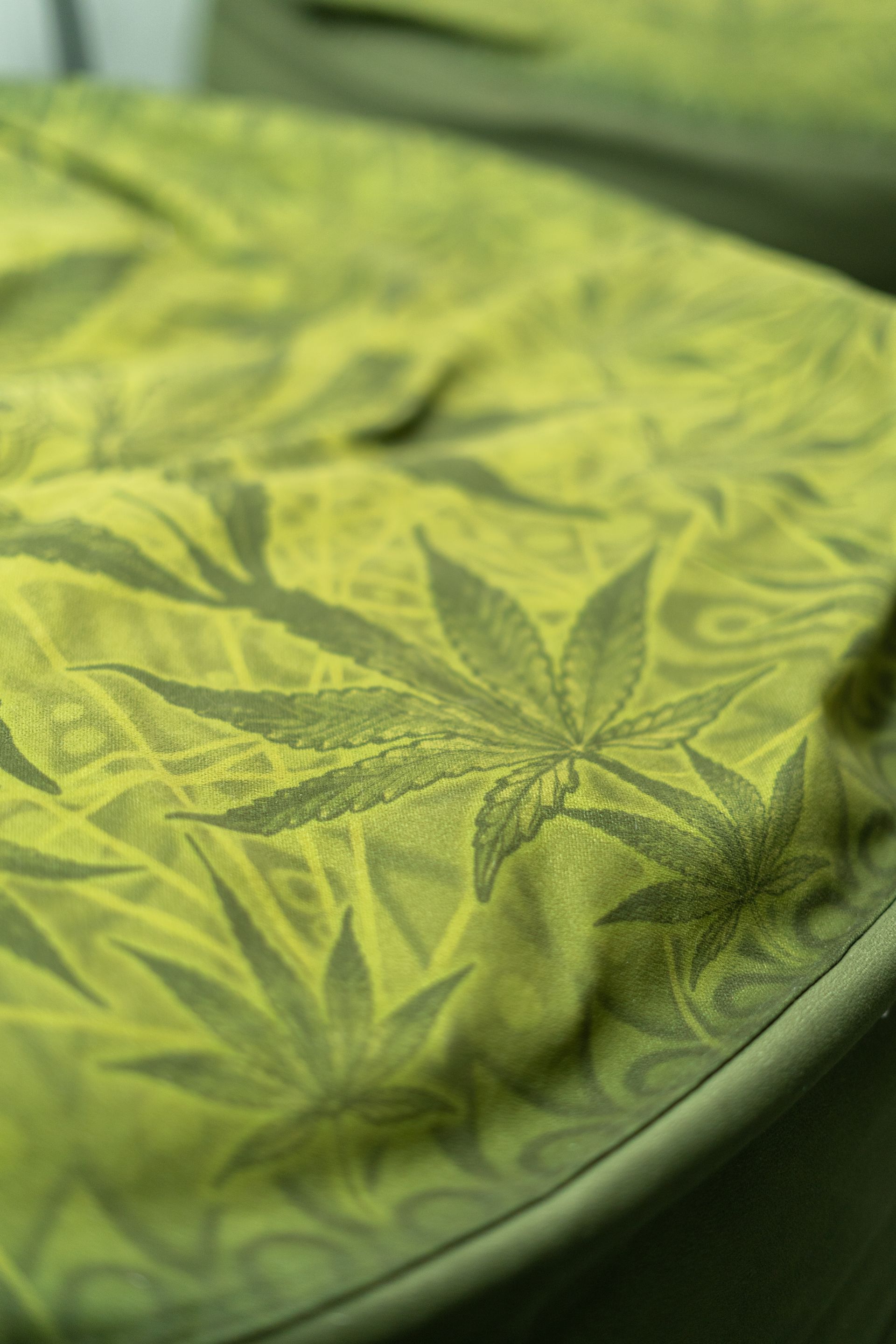 Green fabric with cannabis leaf pattern.
