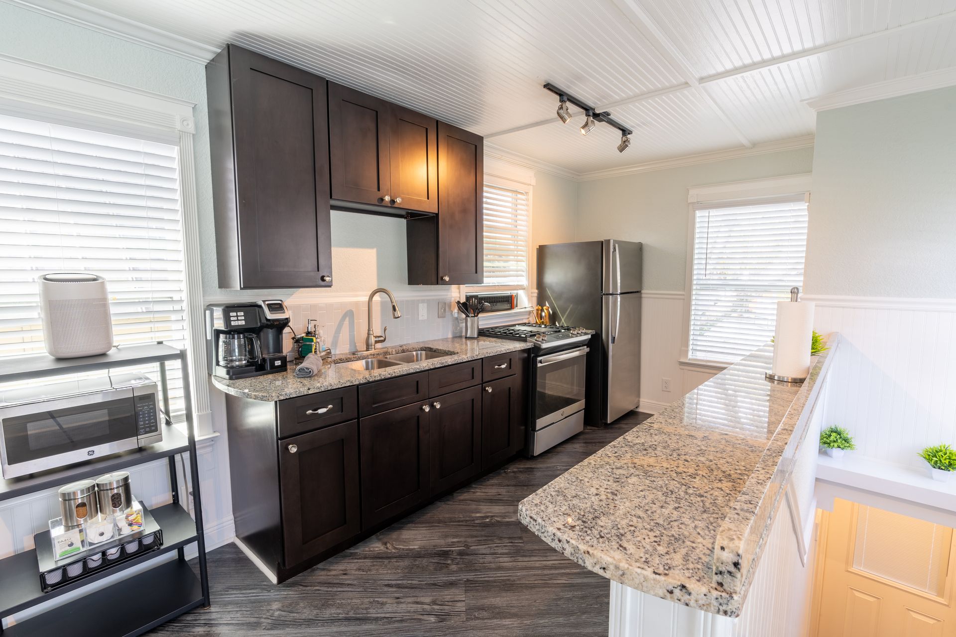 Kitchen with dark cabinets, stainless steel appliances, and a granite countertop.