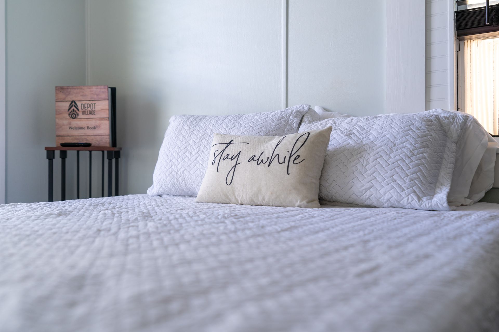 Bed with white bedding and pillows, with a 