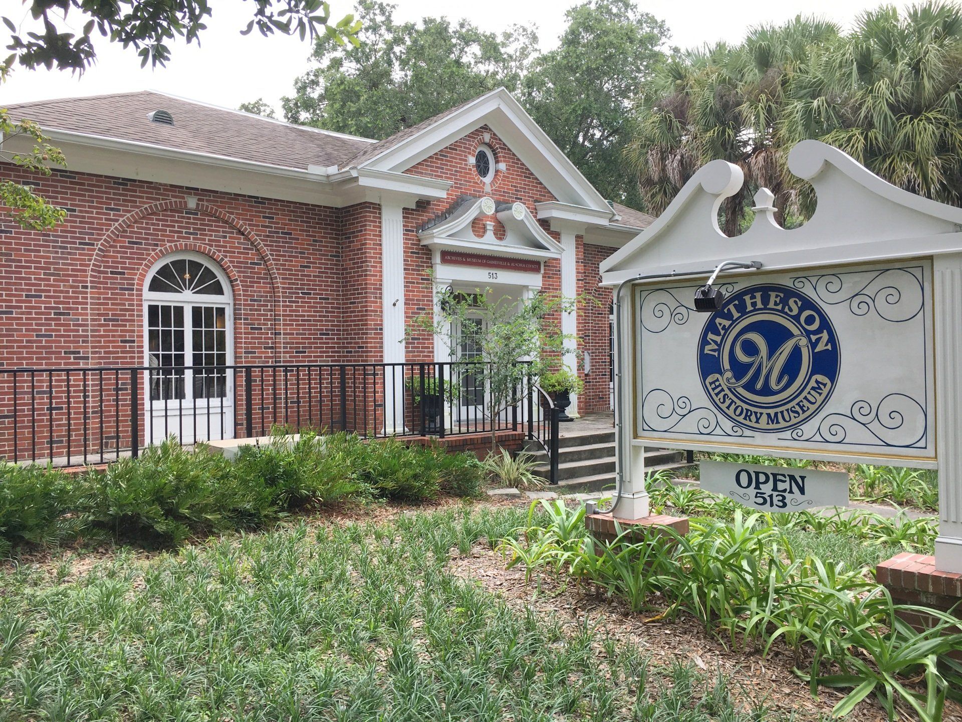 Red brick building with white trim, a sign that reads 