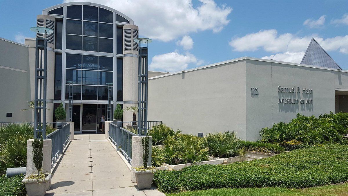 Exterior view of the Beaumont Art League building, with a glass entrance, walkway, and landscaping.