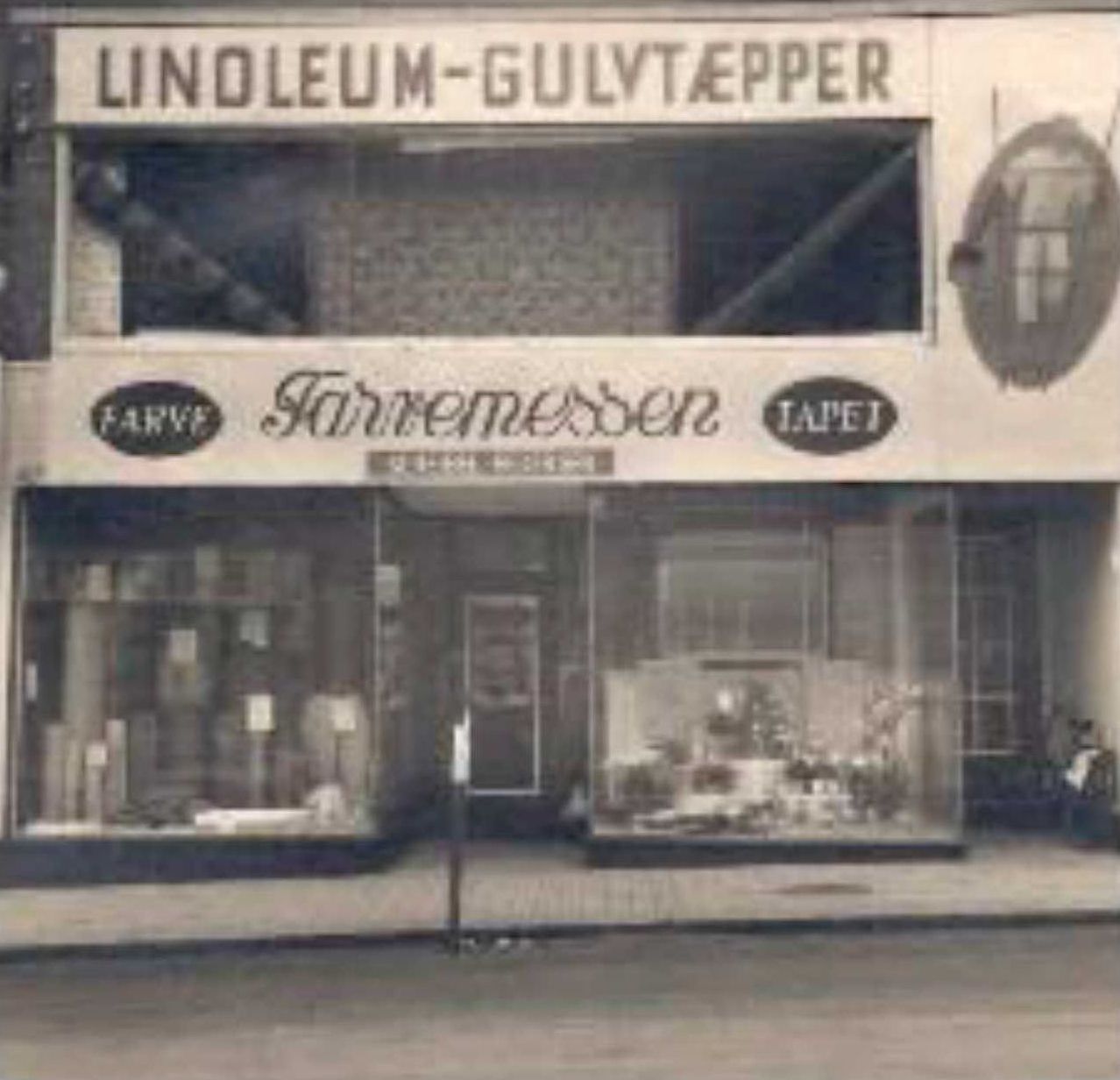 Et sort/hvid foto af en butik kaldet linoleum gulvtapper
