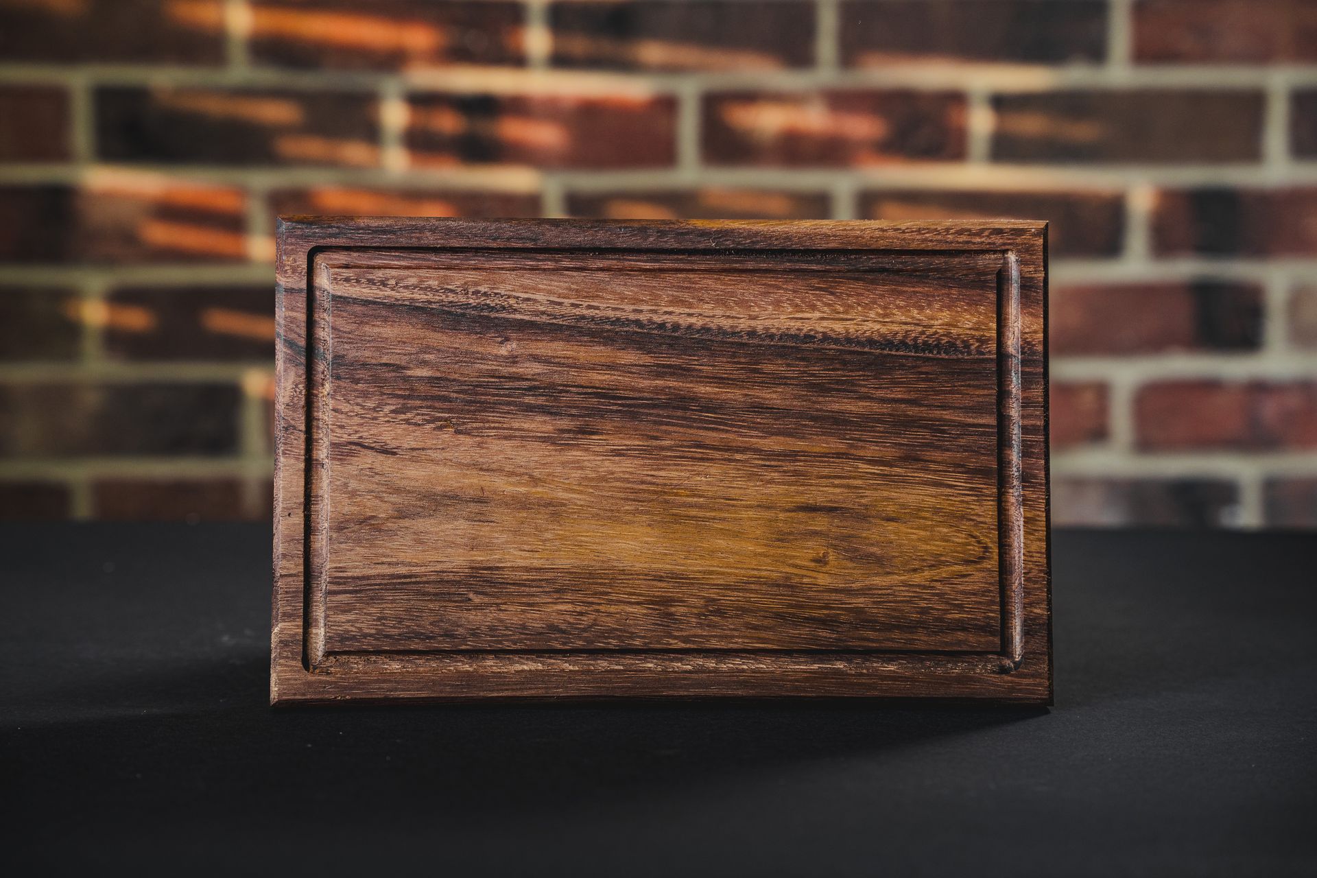 Cajas de madera hechas a mano envueltas con bandas de papel color canela y tela tejida de colores sobre una mesa de madera.