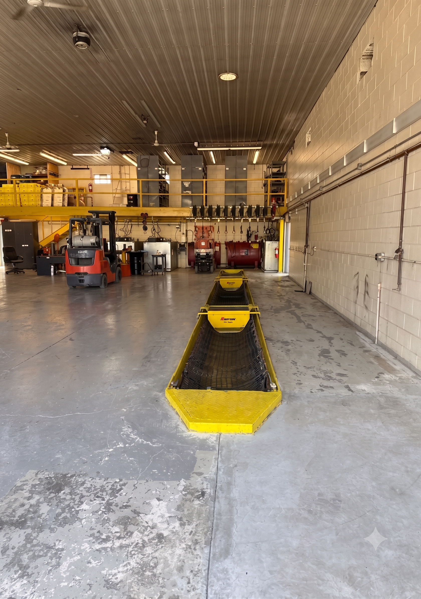 Warehouse interior with a yellow floor lane marker, forklifts, and storage racks under a high ceiling