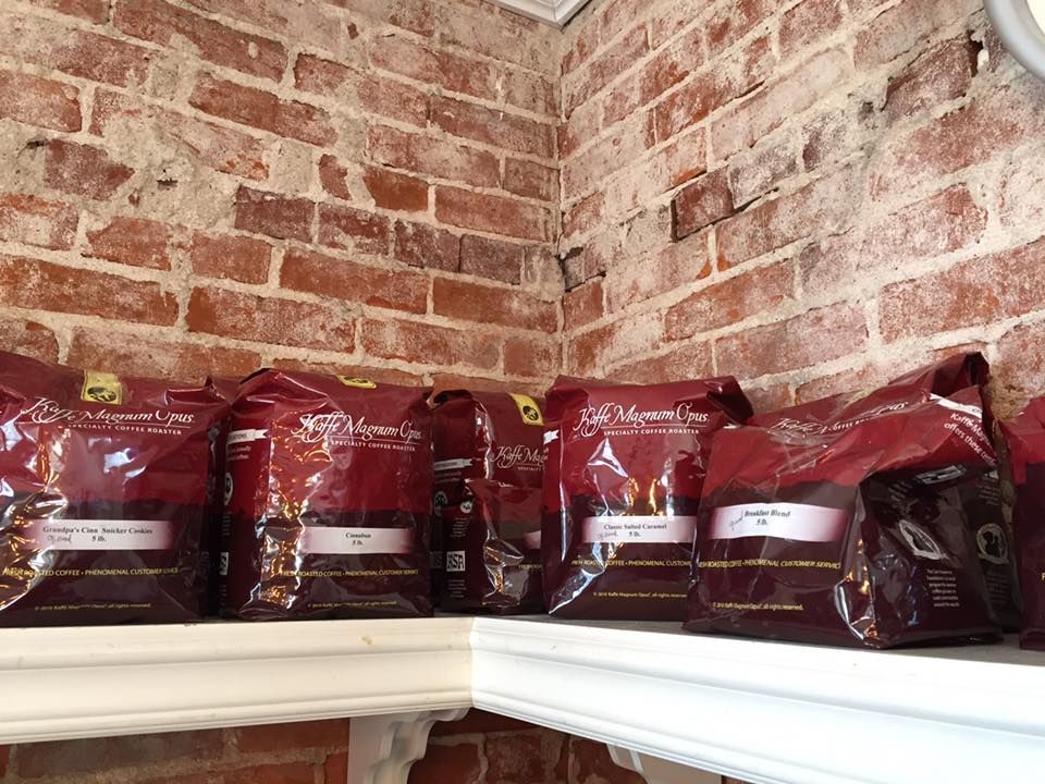 Several bags of food are lined up on a shelf in front of a brick wall