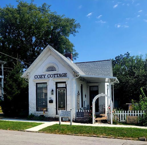 A small white house with the name cozy cottage on it