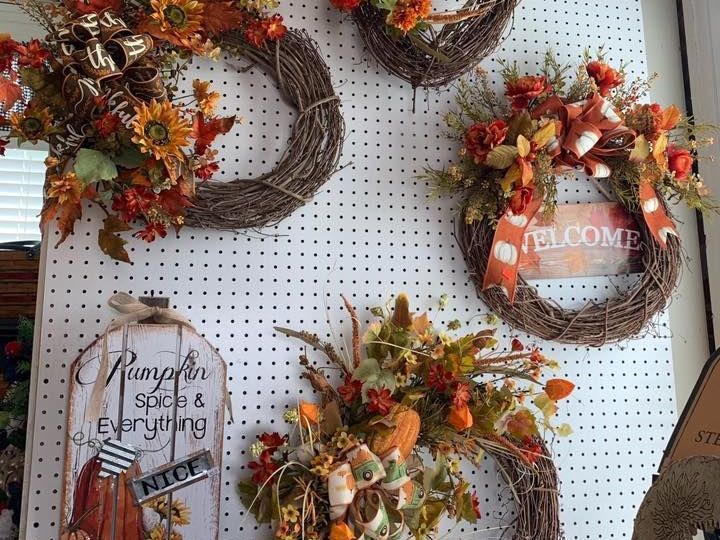 A bunch of wreaths are hanging on a wall.
